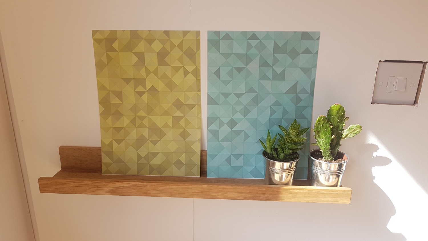 posters of coulered squares with triangles in them on a shelf